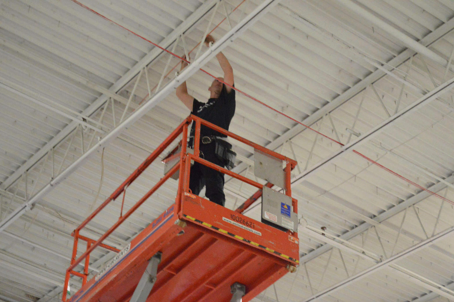 Installer on scissor lift pulling cable